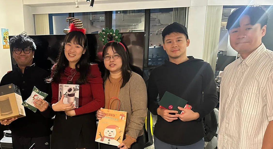 Teammates showing off their holiday gift exchange presents