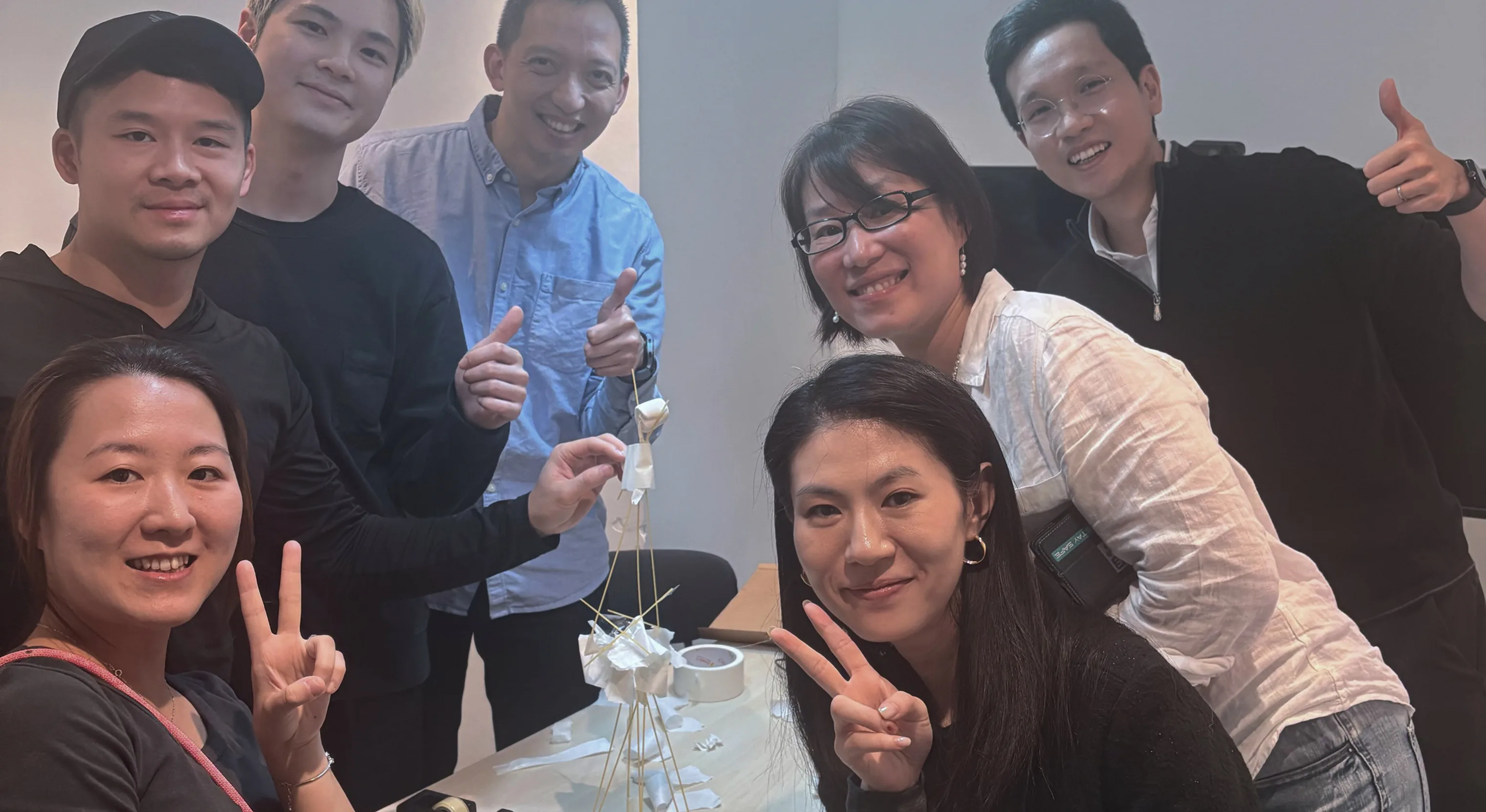 Teammates posing for a selfie during the marshmallow and spaghetti tower challenge
